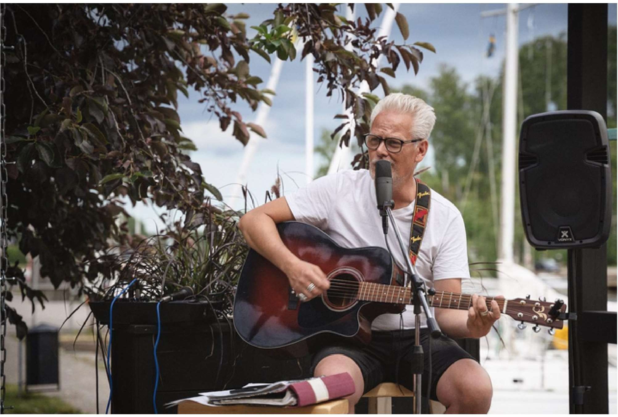 Håkan spelar gitarr vid Söderhamnsån